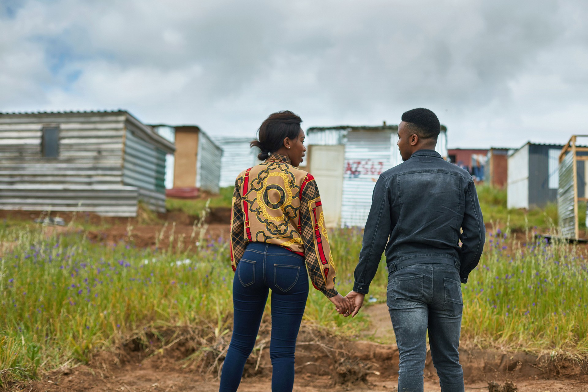 Rear view of young couple holding hands in town