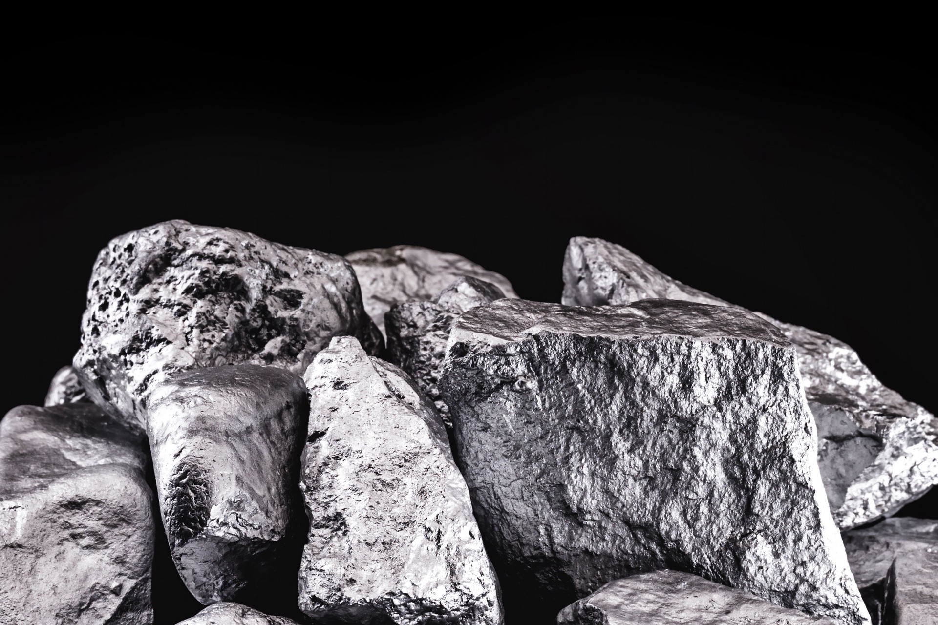 piece of silver or platinum on the stone floor, on black background. Export ore from south africa